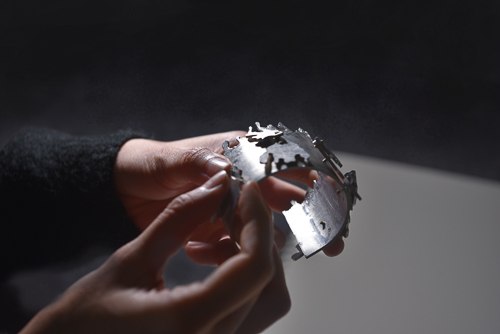 Photo of hands holding a metal bracelet