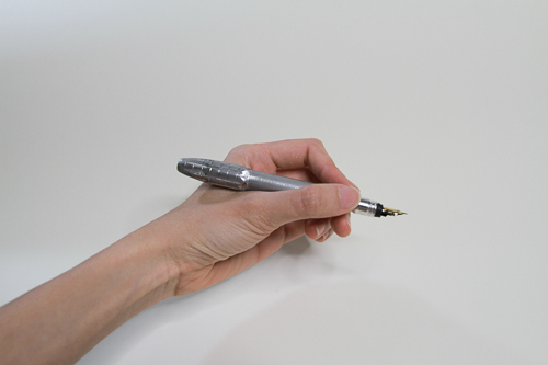 Photo of a hand holding a metal pen